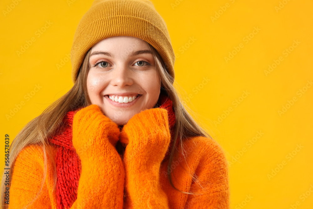 Frozen young woman in winter clothes on yellow background, closeup Frozen young woman in winter clothes on yellow background, closeup