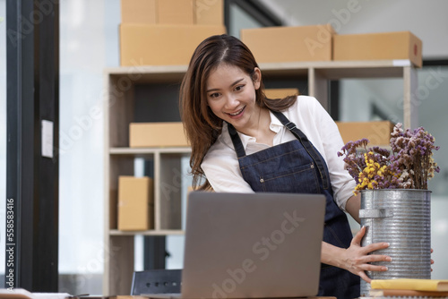 A portrait of a small startup, an SME owner, an Asian female entrepreneur checking orders to arrange the produce before packing the products in the inner boxes with the customers. Freelance concepts