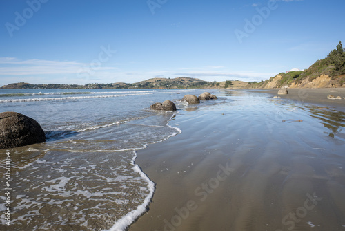 Waves splashing around the boulders at Moeraki Boulders beach  Otago.