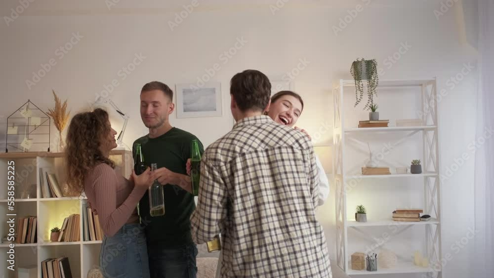 Date party. Happy couple. Enjoying music. Relaxed funny two men and women dancing together in light home room interior.