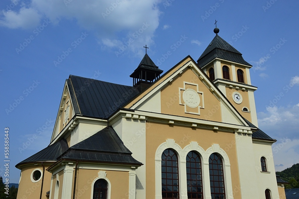 Building of new catholic rectory and church of Assumption of Virgin Mary in pseudo romanesque style in Zazriva, Terchova region, northern Slovakia, during partially cloudy summer day. 