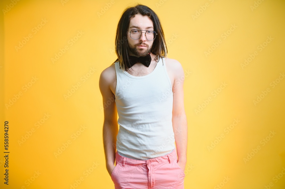 Obraz premium Gay man on a colored background in the studio. The concept of the LGBTQ community. Equality.