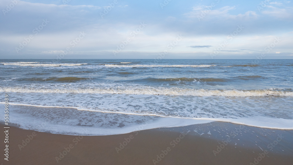 panorama of the North Sea in winter in the weak light of the morning sun with partly cloudy sky in Oostkapelle in Netherlands