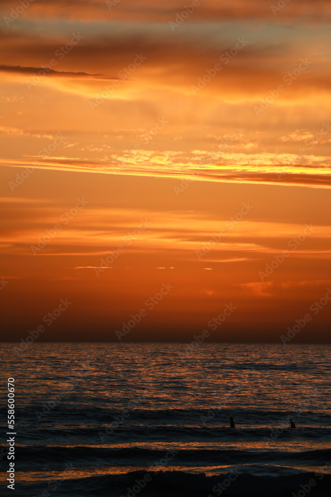 Naklejka premium Beautiful sunset at the beach in portugal at the atlantic ocean close to lissabon. Wallpaper surf