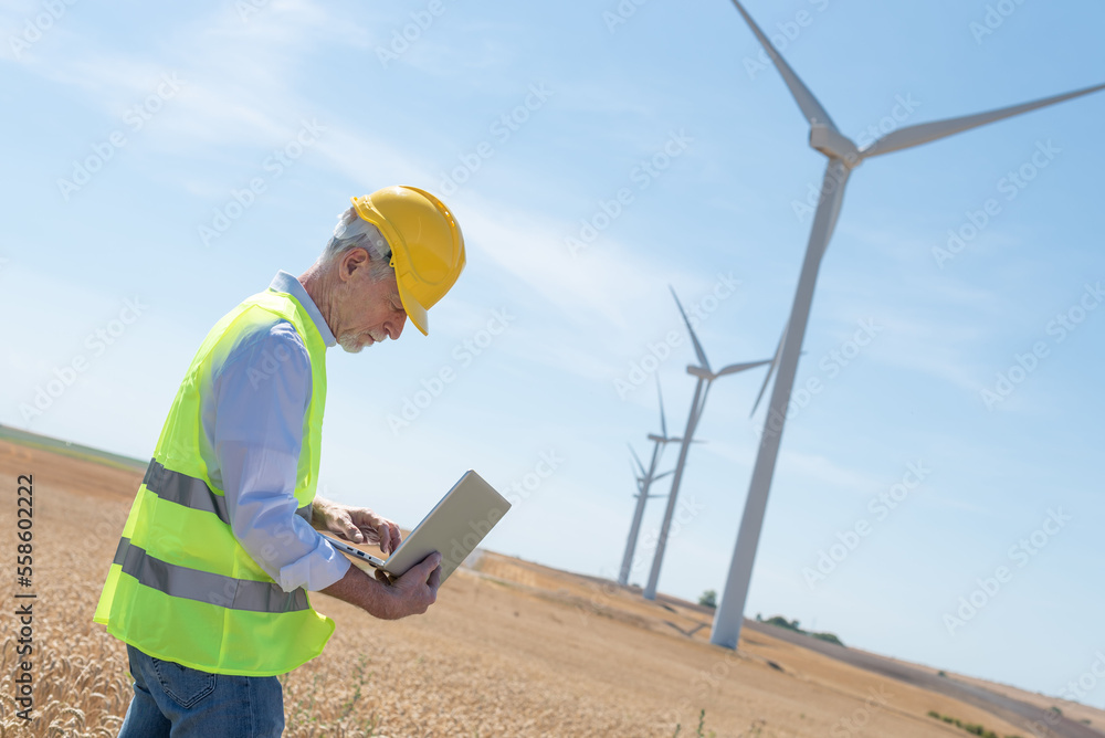 Engineer using laptop for wind turbine inspection Engineer using laptop for wind turbine inspection