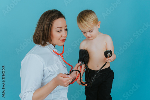 A woman doctor measures the pressure of a child with a tonometer
