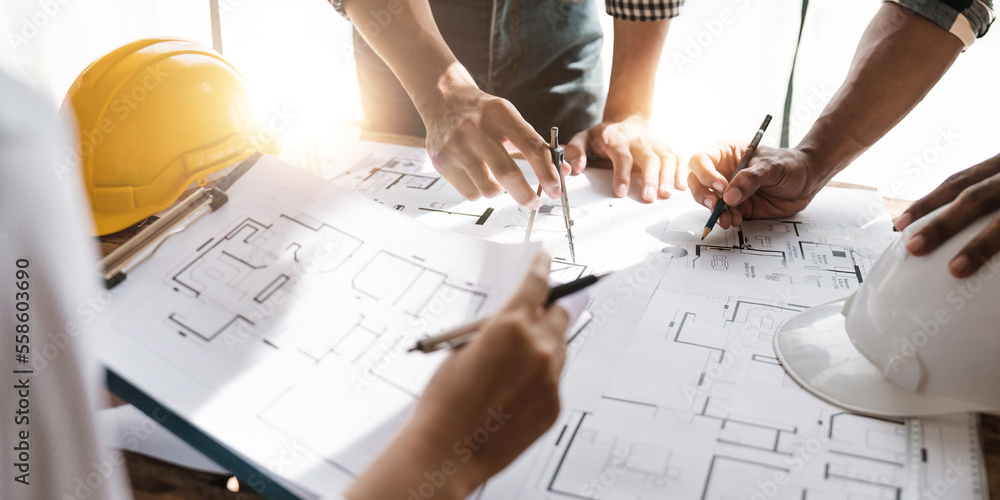 © Natee Meepian - professional architect designer structural engineer team colleagues working office. Architects discussing at the table, team work and work flow construction concept