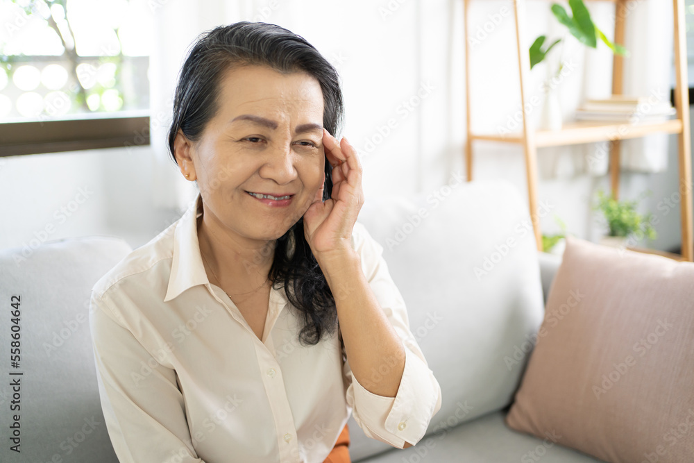 Middle age Asian woman touching forehead having headache suffering from. migraine feeling sick or depression Middle age Asian woman touching forehead having headache suffering from. migraine feeling sick or depression