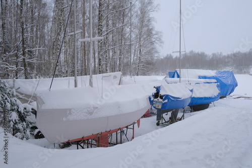 Yacht, boat, ship on the shore under a canopy awning in the snow