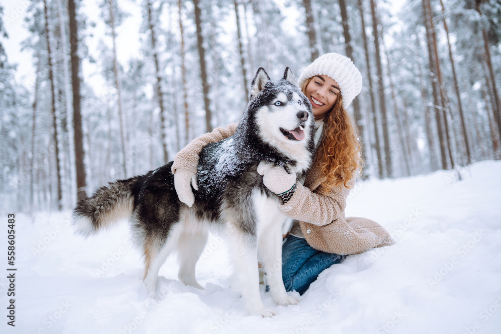 Happy woman walking her dog in the winter and both explore the snow together in playful mood. Friendship, pet and human. Happy woman walking her dog in the winter and both explore the snow together in playful mood. Friendship, pet and human.
