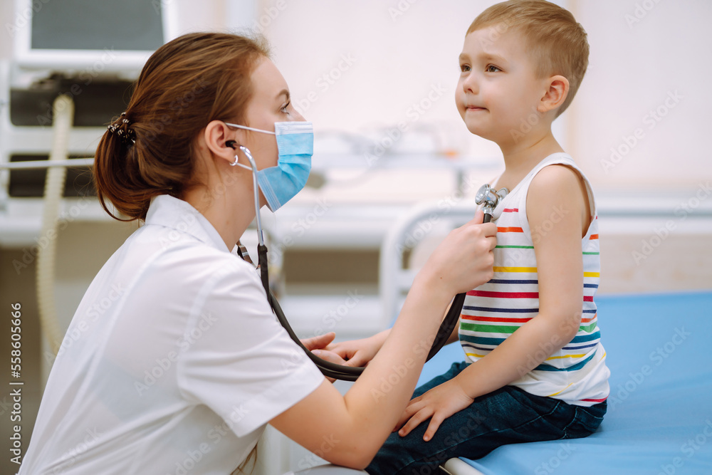 Fototapeta premium Professional general pediatrician in a white dress listen to the sound of the lungs and heart of anpatient with a stethoscope. Сhild's health.