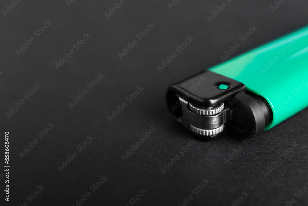 Stylish small pocket lighter on black background, closeup. Space for text Stylish small pocket lighter on black background, closeup. Space for text