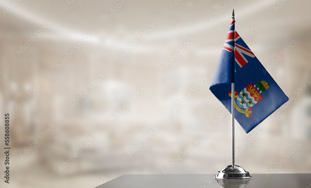 Fototapeta premium A small Cayman Islands flag on an abstract blurry background