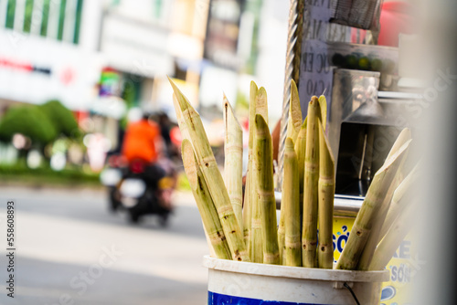 sugarcane in the barrel on street, blurred background. Selective focus