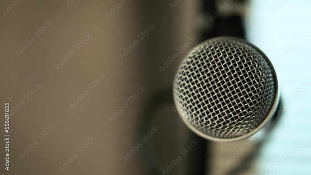 Close-up of a musician hand picking up a microphone for singing. put it on the mic stand. at home studio practice. Close-up of a musician hand picking up a microphone for singing. put it on the mic stand. at home studio practice.