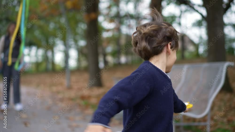 Happy Child running with kite at park during autumn season. One little boy flying kite outdoors having fun Happy Child running with kite at park during autumn season. One little boy flying kite outdoors having fun