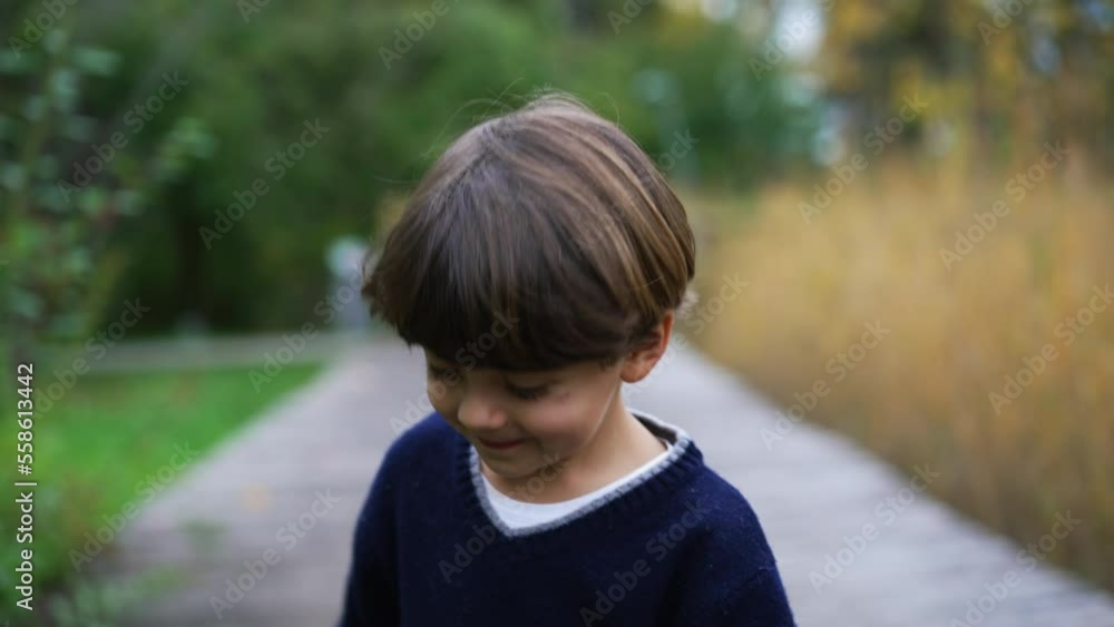 Little boy walking outside in nature. Handsome child enjoying park outdoors during weekend family activity Little boy walking outside in nature. Handsome child enjoying park outdoors during weekend family activity