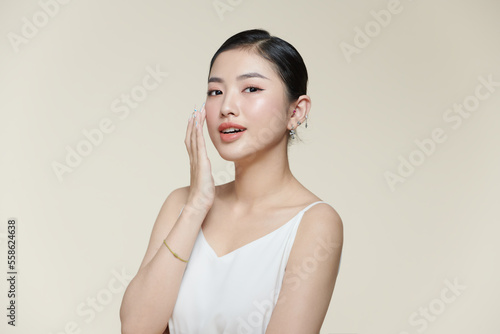 Happy young woman face with clear skin on brown background, closeup portrait