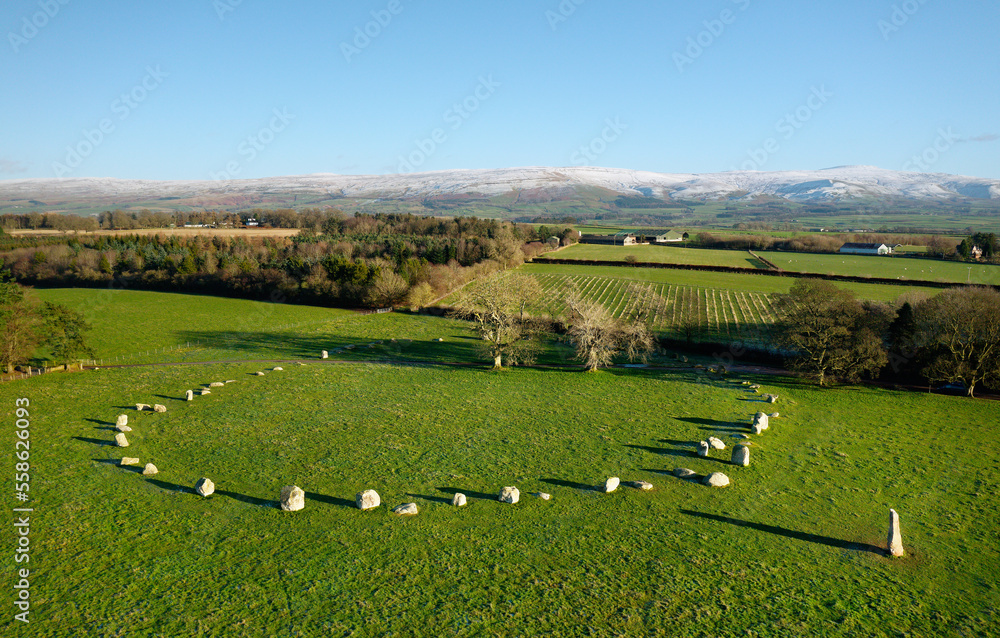 Long Meg and Her Daughters stone circle. Prehistoric Neolithic monument. Langwathby, Cumbria, UK. S.E. over Eden Valley to snow covered Pennines