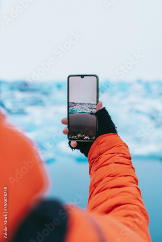 Obraz na płótnie Man photographing a glacier with his smartphone. w salonie