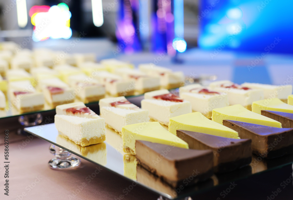 Pieces of cheesecakes on a mirrored tray on the buffet table Pieces of cheesecakes on a mirrored tray on the buffet table
