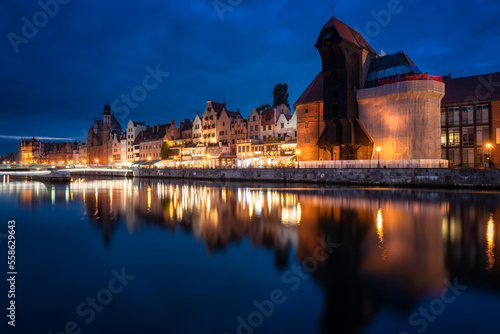 Old town in Gdansk with historical port crane over Motlawa river at night, Poland.