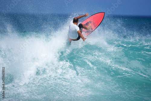 A young man surfing at Rocky Point on the North Shore of Oahu, Hawaii.