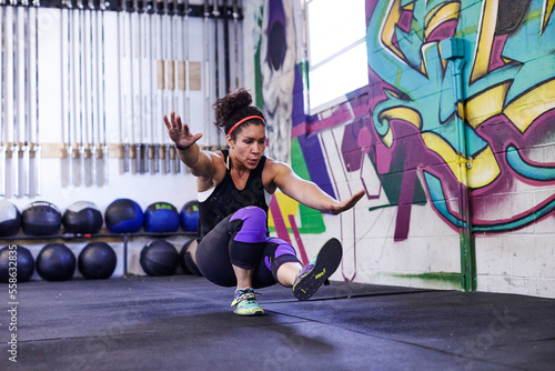 A female athlete trains in a crossfit gym. photo