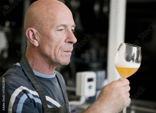 The brewmaster taste tests a new batch of beer at a small brewery in Raervig, Denmark.