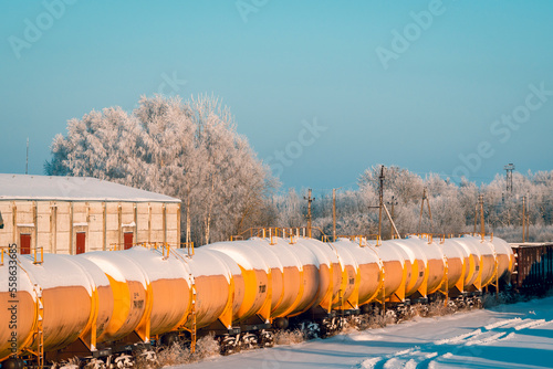 Snow covered tank-wagons with a crude oil standing on the railway