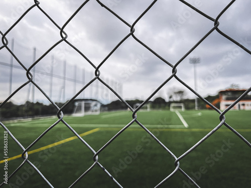 A soccer field view, focusing at the fence