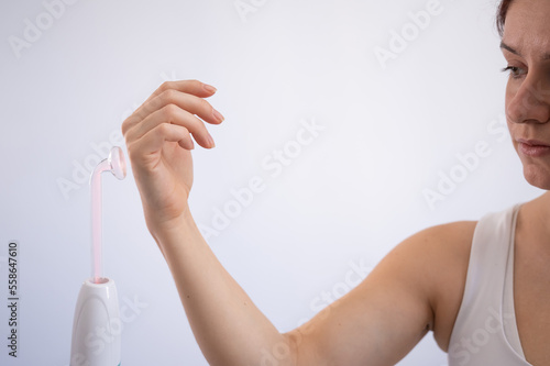 A woman treats her arm with the darsonval device. photo