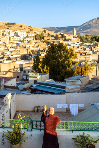 Man on the rooftop enjoying view of Fez old arabic medina, Morocco, Africa