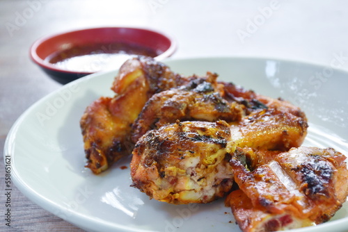 roasted chop chicken wing on plate dipping with spicy sauce