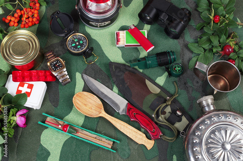 A set of items for survival in nature on a camouflage karemat.