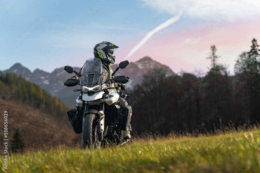 Motorcycle rider in mountains during sunset