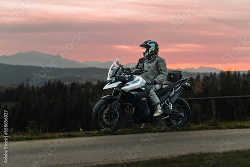 Motorcycle rider in mountains during sunset photo