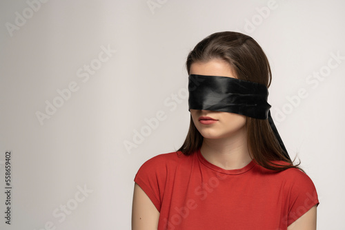Young woman with black veil over her eyes, isolated.