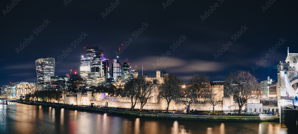 Night long exposure landscape in London, view to skyscrapers office building and Tower Bridge landmark and Thames river. Travel to England.