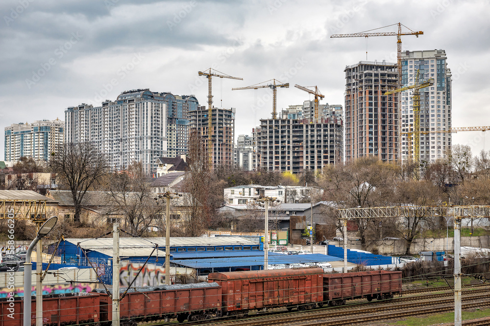 Urban landscape, construction of high new buildings with crane and railroad track