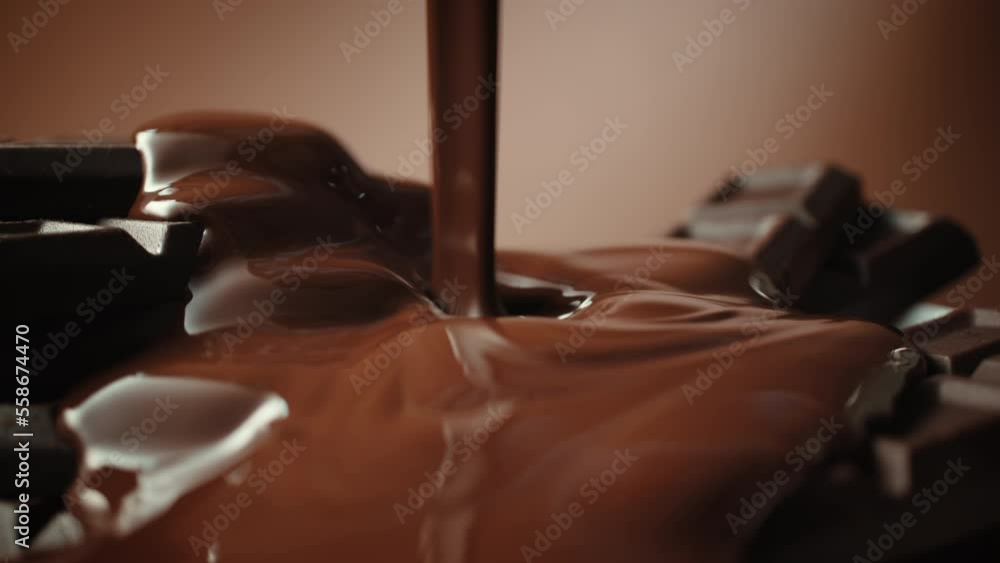 Close-up broken chocolate bar poured with liquid chocolate sauce, lot of homemade chocolate bars and pouring milk chocolate. Handmade, confectionery manufacture