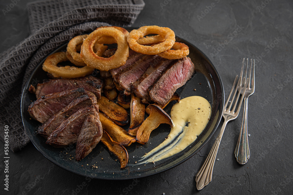 Entrecote Steak vom Rind medium rare gebraten mit Zwiebelringe, Pommes ...