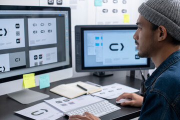 Asian graphic designer working on computer drawing sketches logo design. The concept of a new brand. Professional creative occupation with idea.