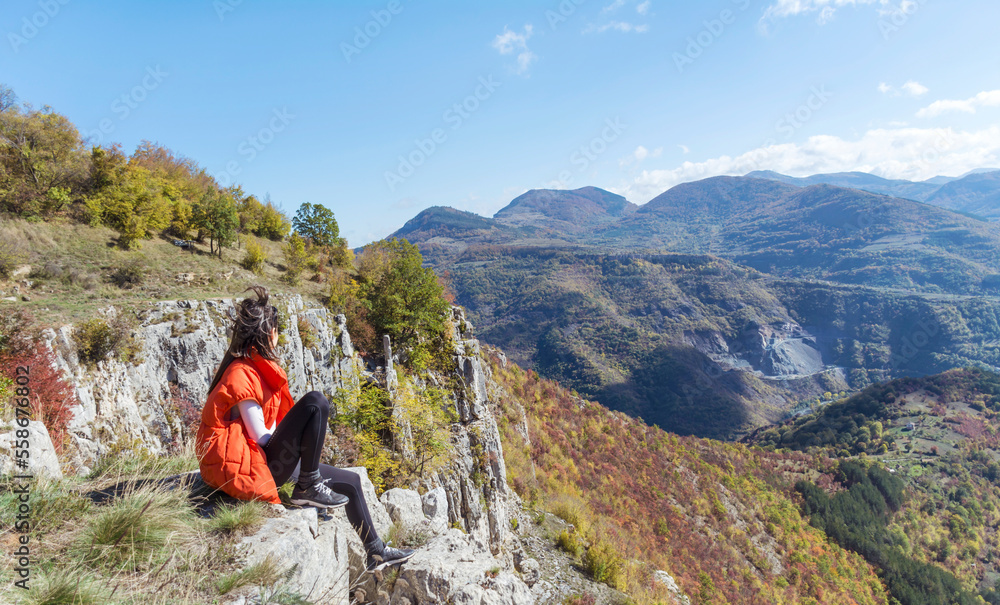 Traveler Woman sitting  on a rocks  in the autumn  mountain with scenery view . Balkan mountains,  ,Bulgaria