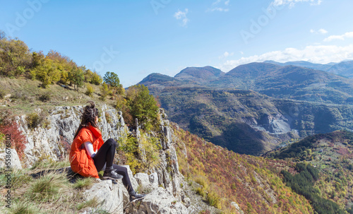 Traveler Woman sitting on a rocks in the autumn mountain with scenery view . Balkan mountains, ,Bulgaria