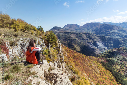 Traveler Woman sitting on a rocks in the autumn mountain with scenery view . Balkan mountains, ,Bulgaria