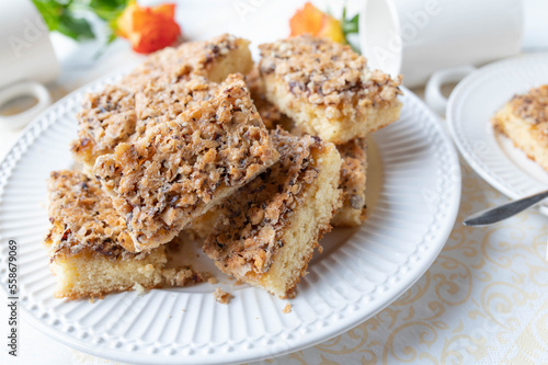 Plate with slices of hazelnut cake on white background © Angelika Heine