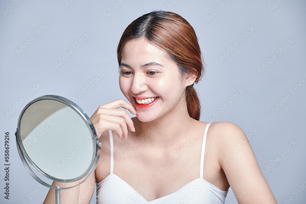 Beauty young asian woman taking care of her skin. Smiling of beautiful pretty asia girl clean fresh healthy white skin face looking at mirror. Beauty young asian woman taking care of her skin. Smiling of beautiful pretty asia girl clean fresh healthy white skin face looking at mirror.