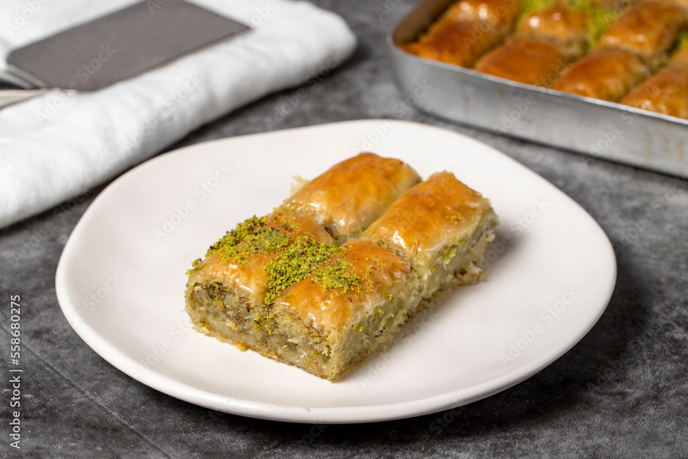 Baklava with pistachio on a dark background. Traditional Turkish baklava in a plate. Studio shoot. close up Baklava with pistachio on a dark background. Traditional Turkish baklava in a plate. Studio shoot. close up