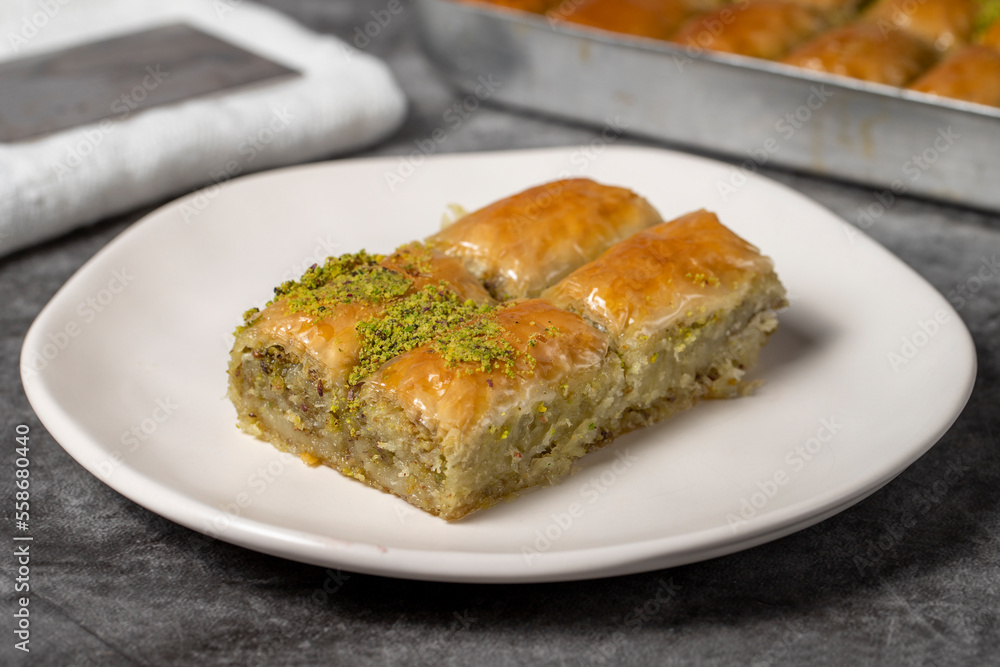 Baklava with pistachio on a dark background. Traditional Turkish baklava in a plate. Studio shoot. close up Baklava with pistachio on a dark background. Traditional Turkish baklava in a plate. Studio shoot. close up